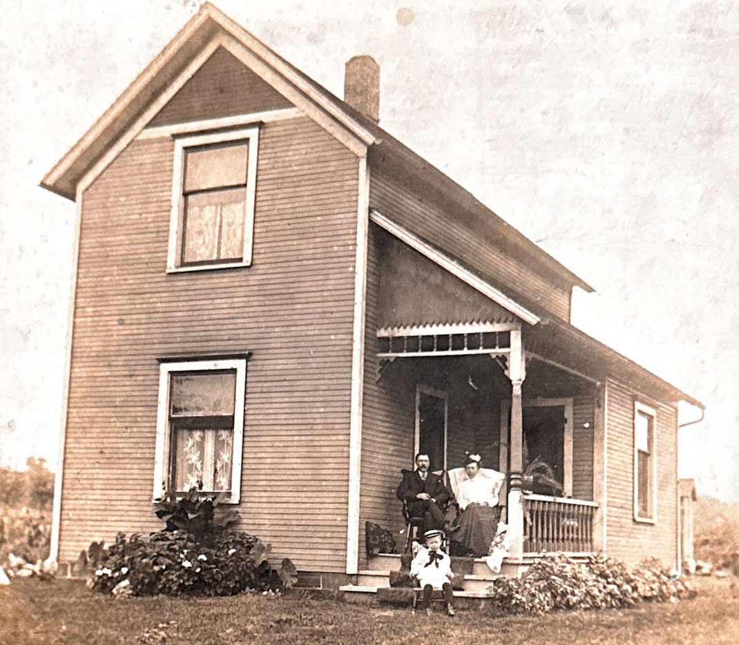 The house on High Street in Barberton. The porch entrance to the mother-in-law room at the back. Pictured are Archie, Annie, and little Clifford Romig in the sailor suit.